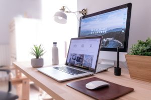 MacBook Pro auf dem Tisch neben dem weißen iMac und der Magic Mouse