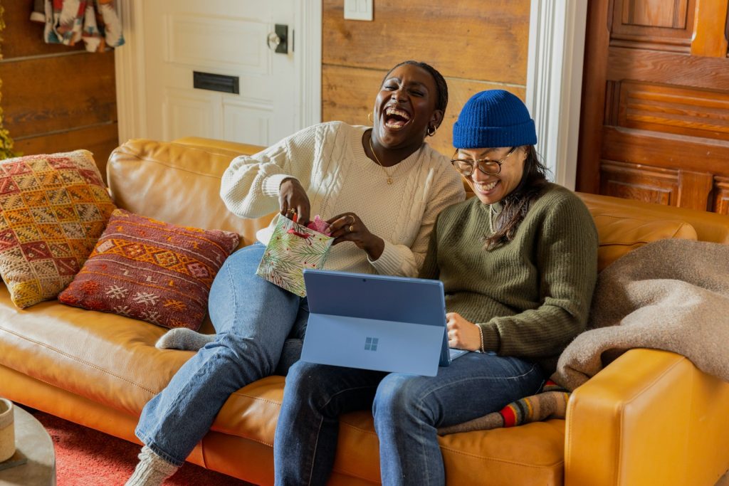 eine Person, die auf einer Couch mit einem Laptop sitzt